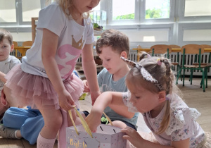 dziewczynka z koroną wręcza prezenciki