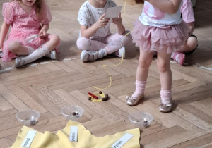 dziewczynka nawleka koralik na sznurek