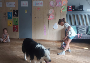 Dziewczynka szykuje psu wodę do picia
