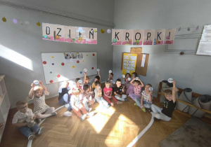 Na zdjęciu widzimy dzieci z grupy 1. Wszystkie dzieci trzymają w rękach kropkę, na której napisane jest Dzień Kropki.