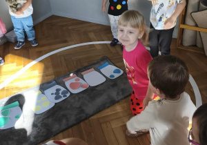 Na zdjęciu widzimy grupkę dzieci, które zamieniły się w małe kropki, które mają za zadanie skakać.