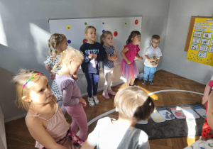 Na zdjęciu widzimy grupkę dzieci, które zamieniły się w małe kropki, które mają za zadanie skakać.