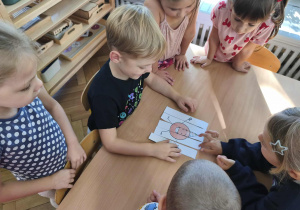 Na zdjęciu widzimy chłopca, który układa puzzle z ilustracją kropki.
