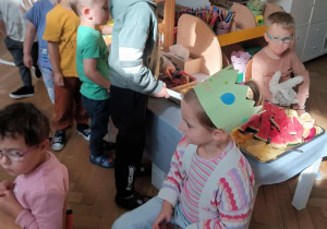 Na zdjęciu widzimy chłopca, który wybiera słodkości i owoce przygotowane przez mamę dziewczynki.