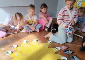 Na zdjęciu widzimy dziewczynkę, która wkłada do miseczek koraliki symbolizujące kolejne lata życia.