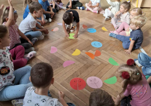 dziecko układa kropkę z dwóch elementów