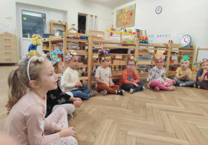 Grupa dzieci zebrana w kole, dzieci opowiadają o swoich opaskach