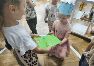 Na zdjęciu widzimy dziewczynkę, która wręcza wykonane laurki Solenizantce.
