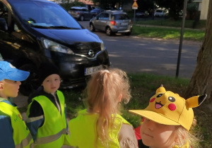 Dzieci stoją na ulicy i obserwują znaki drgowe.