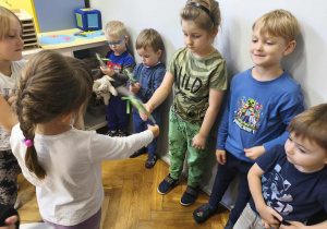 Na zdjęciu widzimy dziewczynki, które wręczją chłopcom drobne upominki.