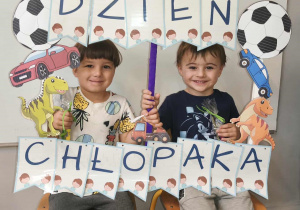 Na zdjęciu widzimy chłopców, którzy pozują do zdjęcia z fotobudką.