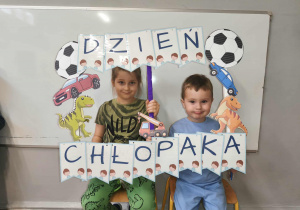 Na zdjęciu widzimy chłopców, którzy pozują do zdjęcia z fotobudką.