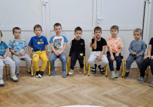 chłopcy siedzą na krzesłach