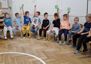 chłopcy trzymają kartki w dłoniach
