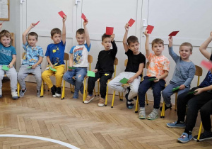 chłopcy trzymają kartki w dłoniach