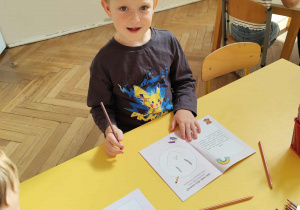 Chłopiec pracuje przy stoliku.
