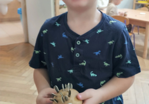 Chłopiec stoi z jeżem w ręku.