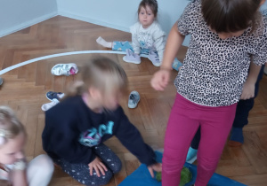 Dziewczynka przechodzi po ścieżce sensorycznej.