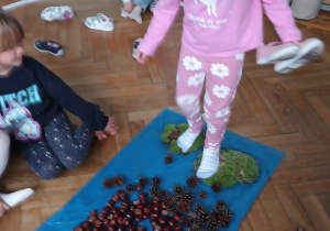 Dziewczynka przechodzi po ścieżce sensorycznej.