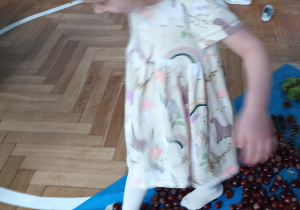Dziewczynka przechodzi po ścieżce sensorycznej.