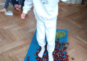 Dziewczynka przechodzi po ścieżce sensorycznej.