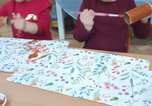 Dziewczynka maluje rolkę po papierze toaletowym.