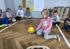 Dzieci układają mandale z darów natury.
