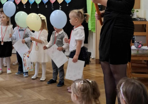Pani Dyrektor przemawiająca do dzieci i trzmająca ołówek do pasowania
