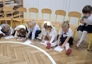 dzieci rysują koło na kartce