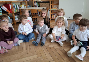 grupa dzieci siedzi na podłodze