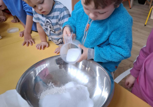 chłopiec wsypuje sól do miski