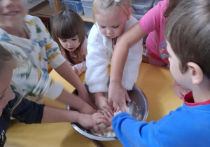 dzieci ugniatają w misce masę solną