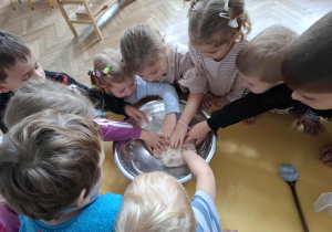 dzieci ugniatają w misce masę solną