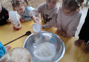 dziewczynka wsypuje sól do miski