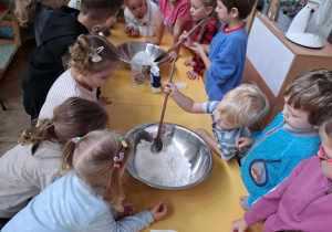 dzieci mieszają łyżkami składniki na masę solną