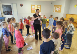 Prowadząca pokazuje dzieciom ćwiczenie do wykonania.