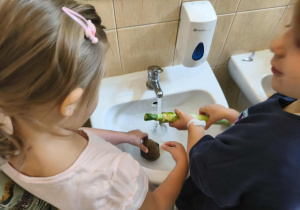 Na zdjęciu widzimy dziewczynki, które myją pod bierzącą wodą buraka i pora.