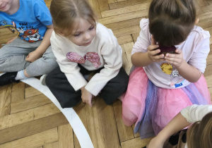 Na zdjęciu widzimy dziewczynkę, która wącha i nawet dotyka nosem przekrojonego na pół buraka.