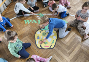 Na zdjęciu widzimy chłopca, który dopasowuje warzywo do jego cienia na wielkiej papryce.