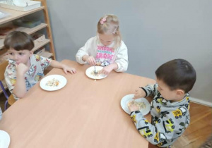 Na zdjęciu widzimy dzieci, które degustują wspólnie wykonanej sałatki.