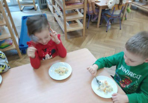 Na zdjęciu widzimy dzieci, które degustują wspólnie wykonanej sałatki.