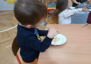 Na zdjęciu widzimy dzieci, które degustują wspólnie wykonanej sałatki.