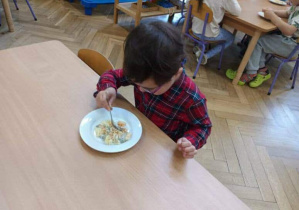 Na zdjęciu widzimy dzieci, które degustują wspólnie wykonanej sałatki.