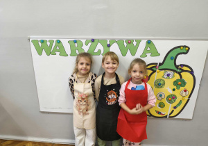 Na zdjęciu widzimy dziewczynki w kolorowych fartuszkach.