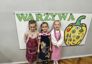 Na zdjęciu widzimy dzieci w kolorowych fartuszkach.