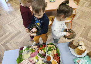 Na zdjęciu widzimy dwójkę dzieci, które wybierają sobie produkty na śniadanie.