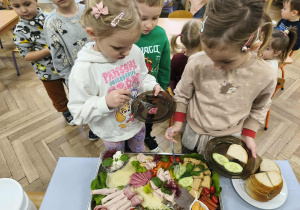 Na zdjęciu widzimy dwójkę dzieci, które wybierają sobie produkty na śniadanie.
