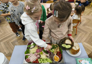 Na zdjęciu widzimy dwójkę dzieci, które wybierają sobie produkty na śniadanie.