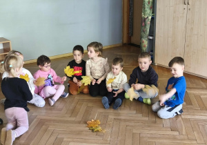 Na zdjęciu widzimy dzieci, które mają za zadanie położyć przed sobą liść.