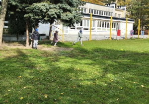 Na zdjęciu widzimy dzieci, które sowbodnie biegają po ogrodzie przedszkolnym.